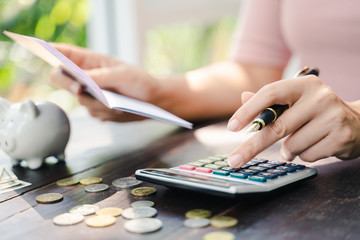 Business woman hands holding saving account passbook with calculator, account and saving concept.