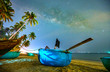 © huythoai - Midnight landscape with basket boat, coconut palm tree Silhouette and Milky Way in the sky on a beautiful summer night. Long exposure photograph.