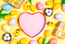 Empty Heart Shape With Easter Eggs, Decorations And Tulips On Yellow Background.