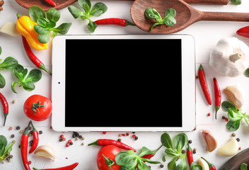 Wall Mural - Top view of tablet, vegetables and spices on white wooden background