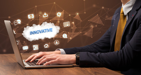 businessman working on laptop with innovative inscription, modern technology concept