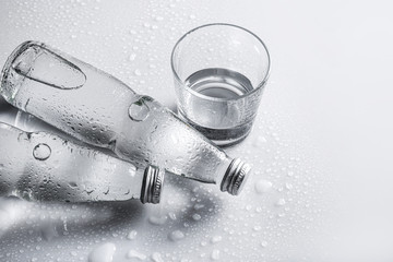 Wall Mural - Glass water bottles and glass of water on white background