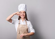 © LumenSt - Young woman in an apron with fresh bread on a gray background. Cook concept