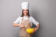 © LumenSt - Young woman in an apron with fresh bread on a gray background. Cook concept