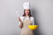 © LumenSt - Young woman in an apron with fresh bread on a gray background. Cook concept