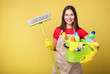© LumenSt - Young woman in apron  on  yellow background. Cleaning concept
