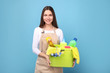 © LumenSt - Young woman in apron  on  blue background. Cleaning concept