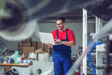 Poster - Industrial engineer with laptop in a  industrial manufacture factory working.