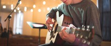 Young Man Playing On Acoustic Guitar