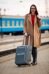 girl in a coat with a suitcase going to the landing zone