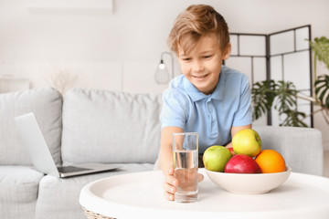 Sticker - Cute little boy taking glass of water from table at home