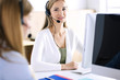© rogerphoto - Portrait of call center operator at work. Group of people in a headset ready to help customers. Business concept