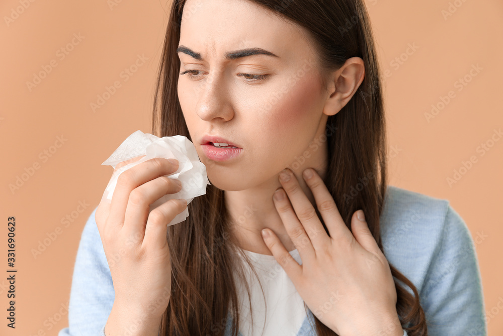 Coughing young woman on color background, closeup