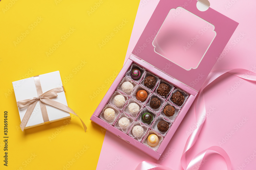 Box with delicious candies on color background