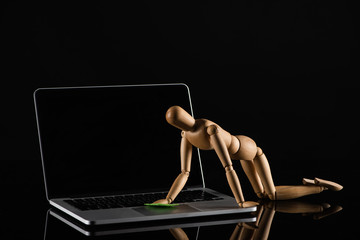 Wall Mural - Wooden doll on all four position imitating dusting laptop on black background