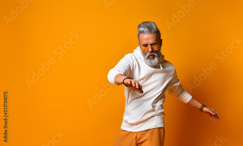 Cuadros en Lienzo Studio shot of modern, hipster businessman pretends dancing, isolated on orange