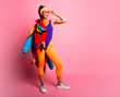 © ClaudiK - Full length fashion portrait of young trendy woman in cap and jeans looking away.young and cool, hipster girl with colored coat, orange leggings  and body suit. 80s 90s style