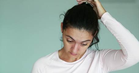 Wall Mural - Pensive woman touching hair with hand casually thinking