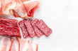 Meat plate with salami, bacon, hamon on a light background. Top view