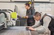 © guruXOX - Two technicians works on CNC computer numerical control cutting machine