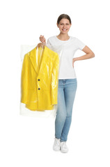 Wall Mural - Young woman holding hanger with jacket in plastic bag on white background. Dry-cleaning service