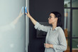 © AnnaStills - Young businesswoman wiping the whiteboard she preparing it for future presentation at office