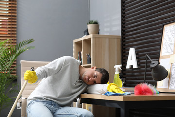 Canvas Print - Lazy man procrastinating while cleaning at home