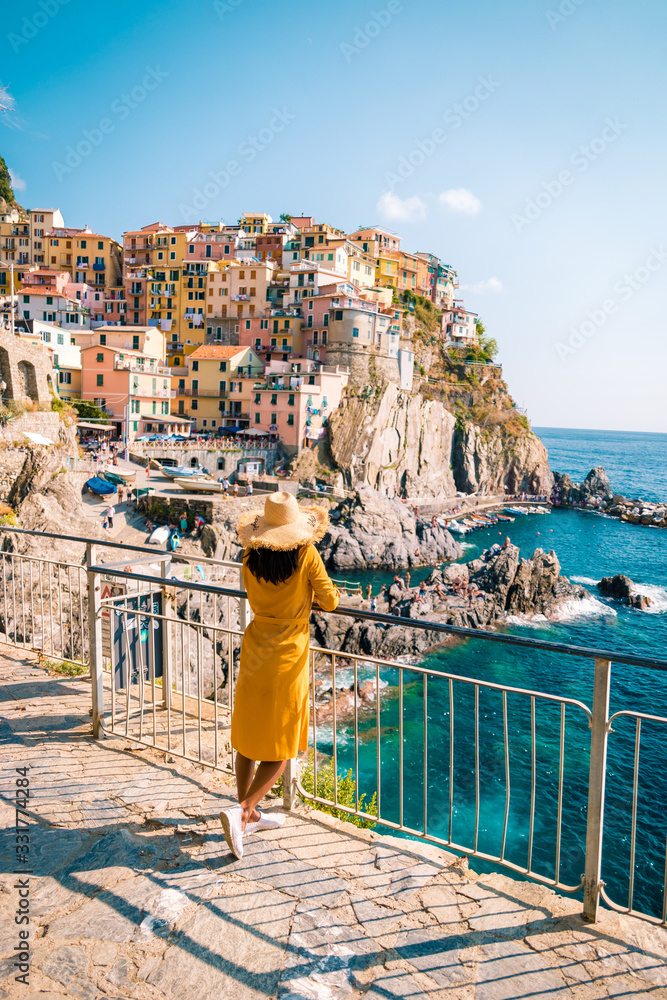 woman visit Manarola Village, Cinque Terre Coast Italy. Manarola is a beautiful small colorful town province of La Spezia, Liguria, north of Italy and one of the five Cinque terre national park - obrazy, fototapety, plakaty 