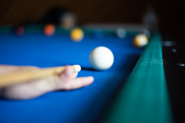 Man plays billiards on a blue table