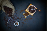 Antique manual coffee grinder, cup of coffee and beans, on wooden backgrounds.