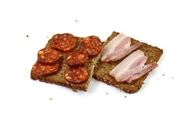 Poster - Slice of wholemeal dark bread with smoked sausage and bacon isolated on a white background in close-up