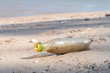 Plastic bottle is on the beach leave by tourist