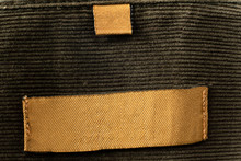 Yellow Blank Clothes Label On Worn Brown Green Shirt Background