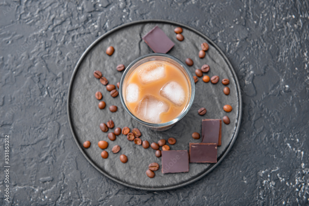 Glass of tasty iced coffee on dark background