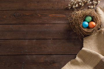 Still life many colorful easter eggs on a wooden background. Rustic. Decoration from natural fabrics and herbs. Easter celebration concept. Flat lay