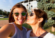 © ClaudiK - Mother and adult daughter are doing selfie in the park going crazy and showing tongueSunset light.Happy and positive emotions.Hipster family.Parents and teenagers.Summer vacation self-portrait