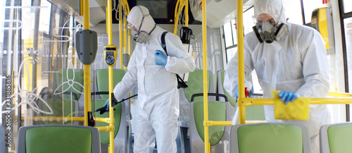 HazMat team in protective suits decontaminating public transport, bus interior d Tableau sur Toile