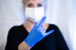 © Alexandra - Senior woman wearing mask and gloves shows the rock sign. Selective focus. Coronavirus and epidemic virus symptoms.
