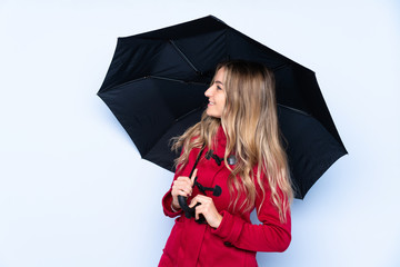 Young woman with winter coat and  holding an umbrella with happy expression