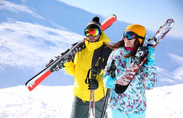 Sticker - Young couple with skis on hill. Winter vacation