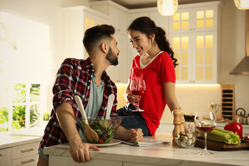 Poster - Lovely young couple cooking salad together in kitchen