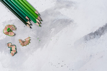 Green pencils on a white stone table