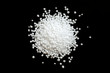 © aneriksson - Urea fertilizer on a black background, top view. White mineral fertilizer balls - urea (carbamide). Urea nitrogen fertilizer on a black background.