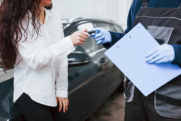 Female customer takes back her auto in car washing service