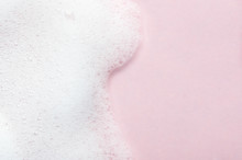 Foaming Liquid On Pink Backdrop. Cosmetics Foam Background With Copy Space In Right Side. Cosmetic Product Sample Of Mousse, Shampoo Or Soap. Skincare, Cosmetology And Beauty Concept