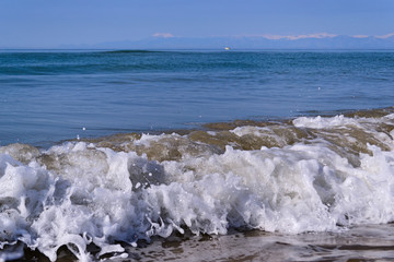 Waves with foam close up on a tropical sandy beach. Copy space for background