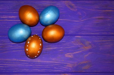 Wall Mural - Multi-colored Easter eggs on a wooden background