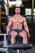 © cirkoglu - Sexy muscular man doing leg extension exercise on the machine