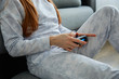 © bestsenny - A close shot of the hands of a red-haired girl with a game console sitting on the floor.