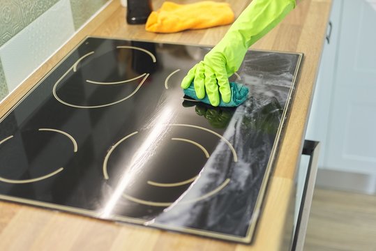 Closeup of hand woman cleaning modern cooking glass